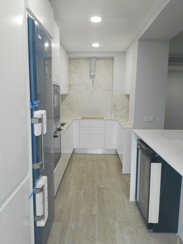 Foto di una piccola cucina minimal con lavello sottopiano, ante lisce, ante bianche e pavimento con piastrelle in ceramica