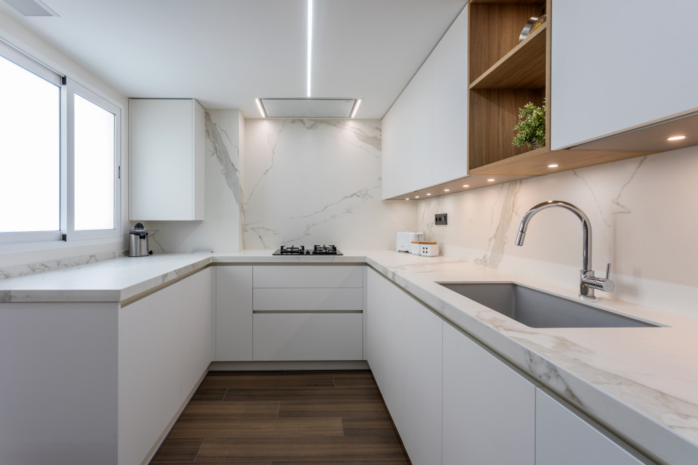 This is an example of a large scandinavian l-shaped kitchen/diner in Valencia with a submerged sink, stainless steel appliances, porcelain flooring and brown floors.