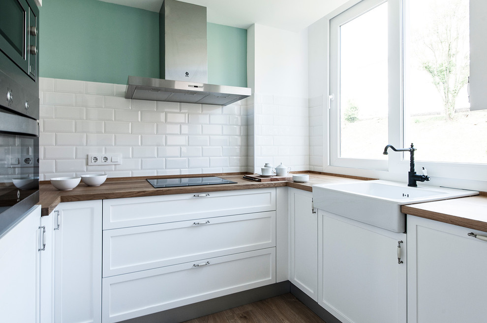 Photo of a small classic u-shaped enclosed kitchen in Other with a single-bowl sink, recessed-panel cabinets, white cabinets, wood worktops, white splashback, metro tiled splashback, stainless steel appliances, dark hardwood flooring and no island.