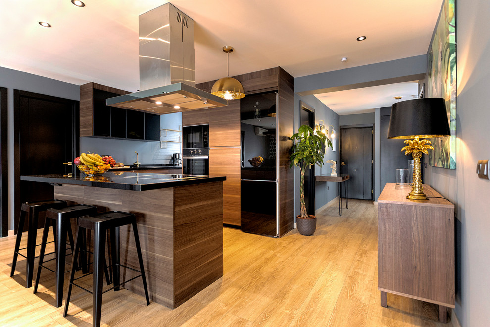 Esempio di una cucina contemporanea di medie dimensioni con ante lisce, ante in legno scuro, paraspruzzi grigio, elettrodomestici neri, pavimento in legno massello medio, pavimento beige e top nero