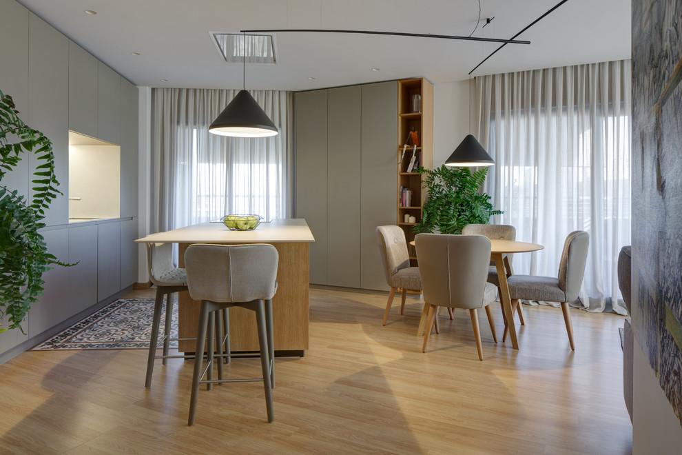 Einzeilige, Mittelgroße Moderne Wohnküche mit flächenbündigen Schrankfronten, weißen Schränken, Laminat, Kücheninsel und braunem Boden in Alicante-Costa Blanca