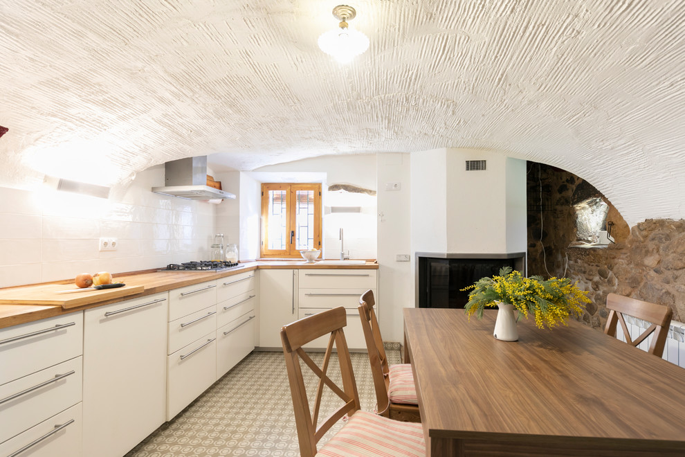 Esempio di una grande cucina mediterranea con lavello da incasso, ante lisce, ante bianche, top in legno, paraspruzzi bianco e pavimento multicolore