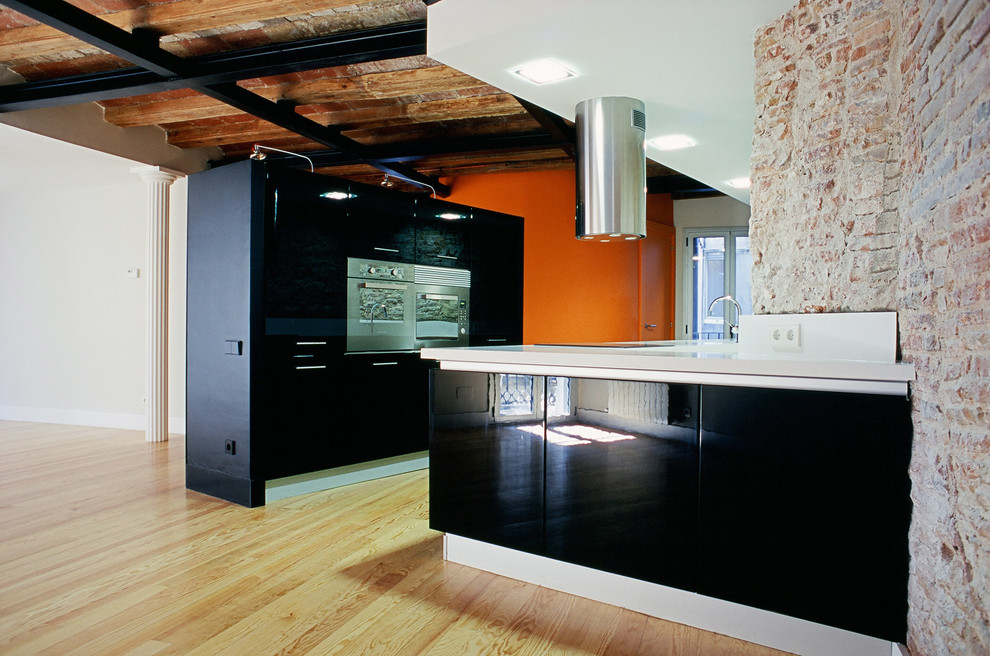 Imagen de cocina urbana grande abierta sin isla con armarios con paneles lisos, puertas de armario negras y suelo de madera en tonos medios