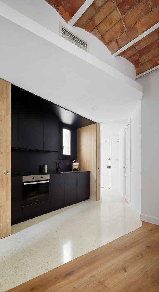 Идея дизайна: прямая кухня-гостиная среднего размера в современном стиле с плоскими фасадами, черными фасадами, черным фартуком и черной техникой без острова