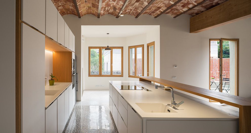 На фото: большая параллельная кухня-гостиная в стиле лофт с плоскими фасадами, белыми фасадами и островом с