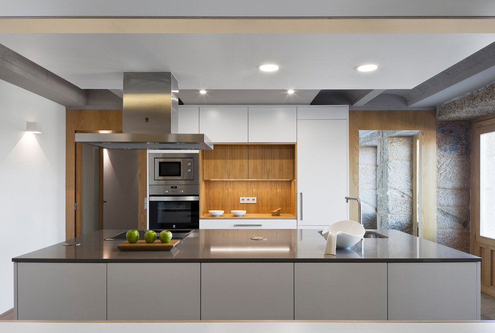 Idéer för ett mellanstort modernt linjärt kök med öppen planlösning, med släta luckor, vita skåp, rostfria vitvaror och en köksö