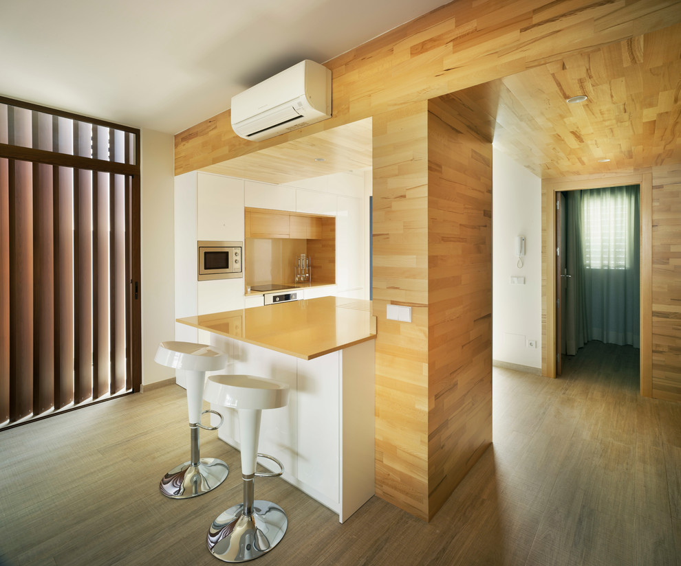 Foto di una cucina design di medie dimensioni con ante lisce, ante bianche, pavimento in legno massello medio, penisola e top arancione