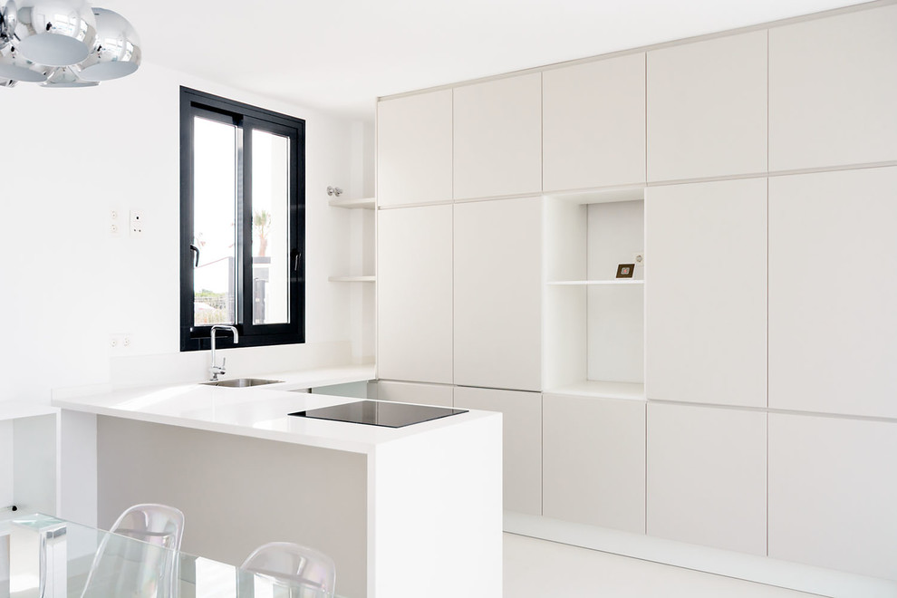 Foto de cocinas en L minimalista abierta con armarios con paneles lisos, puertas de armario blancas, salpicadero blanco y península