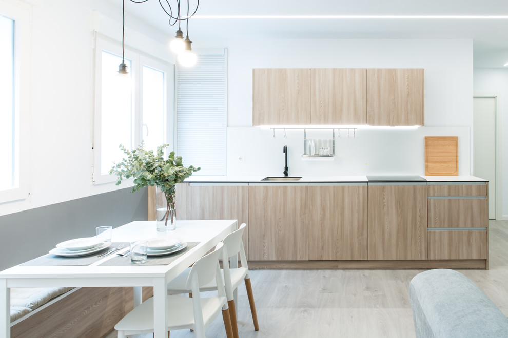 Modelo de cocina comedor escandinava con fregadero bajoencimera, armarios con paneles lisos, puertas de armario de madera clara y suelo de madera clara