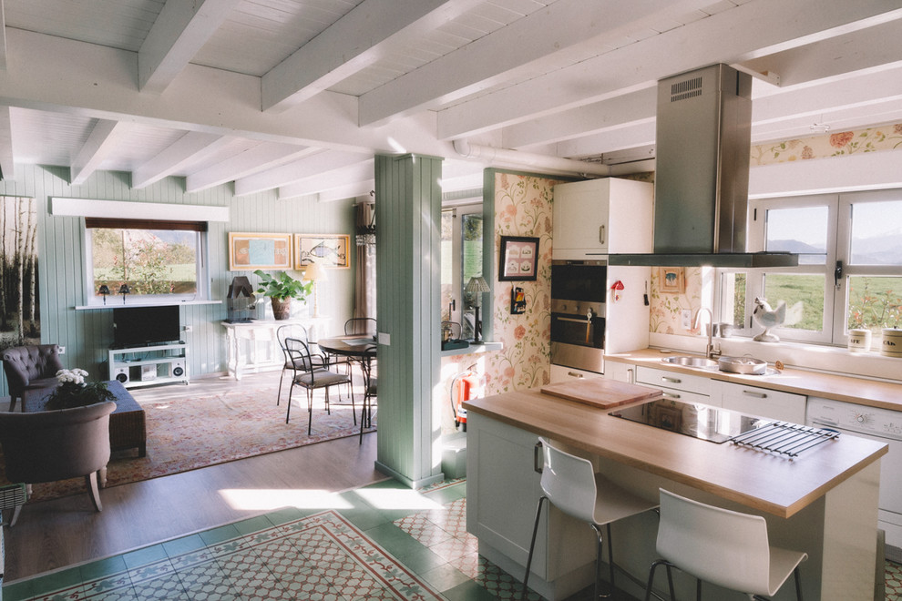 Foto på ett mellanstort lantligt linjärt kök med öppen planlösning, med släta luckor, vita skåp, träbänkskiva och en köksö