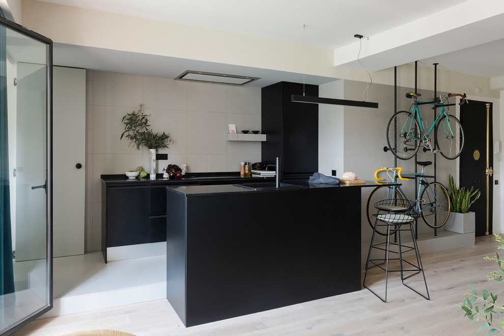 Идея дизайна: прямая кухня-гостиная среднего размера в современном стиле с плоскими фасадами, черными фасадами, бежевым фартуком, островом и черной столешницей
