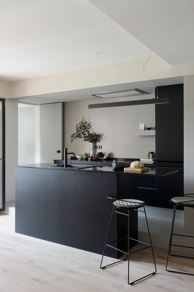 Offene, Einzeilige, Mittelgroße Moderne Küche mit flächenbündigen Schrankfronten, schwarzen Schränken, Küchenrückwand in Beige und Kücheninsel in Barcelona