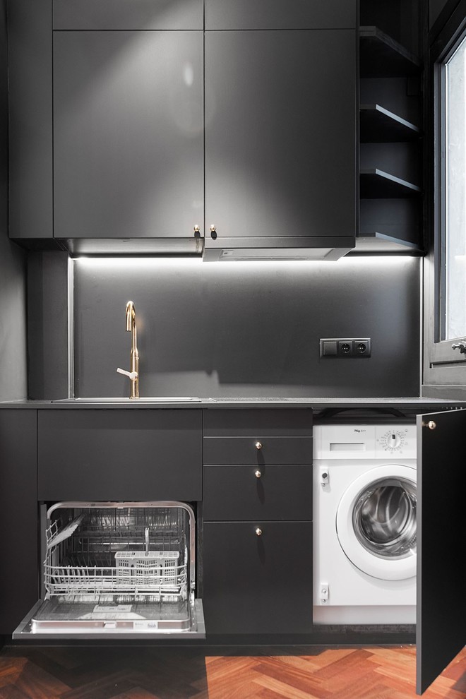 Idee per una cucina minimal con ante lisce, ante nere, paraspruzzi nero e pavimento in legno massello medio
