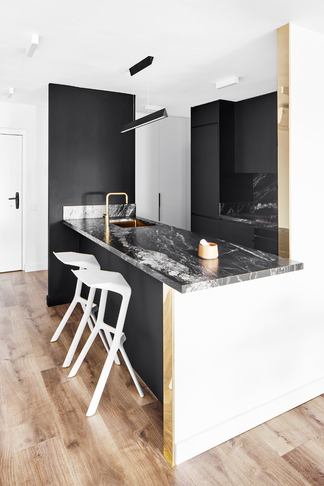 Идея дизайна: прямая кухня-гостиная в современном стиле с врезной мойкой, плоскими фасадами, черными фасадами, черным фартуком, полуостровом и черной столешницей