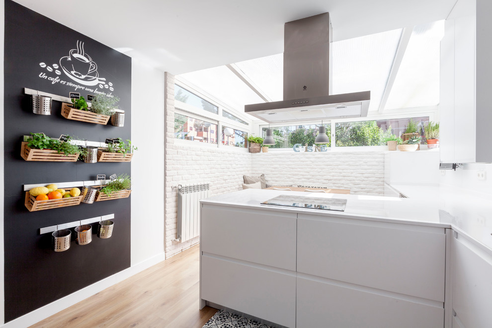 マドリードにある中くらいなコンテンポラリースタイルのおしゃれなキッチン (フラットパネル扉のキャビネット、白いキャビネット、クオーツストーンカウンター、白いキッチンパネル、無垢フローリング) の写真