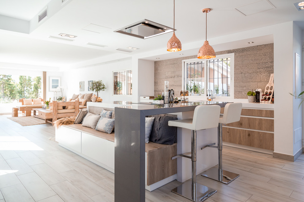 На фото: прямая кухня-гостиная среднего размера в морском стиле с плоскими фасадами, светлыми деревянными фасадами, светлым паркетным полом и островом с