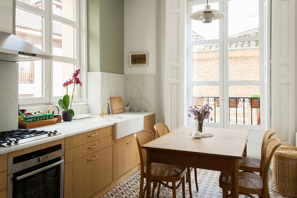 This is an example of a medium sized classic single-wall kitchen/diner in Madrid with flat-panel cabinets, medium wood cabinets and no island.