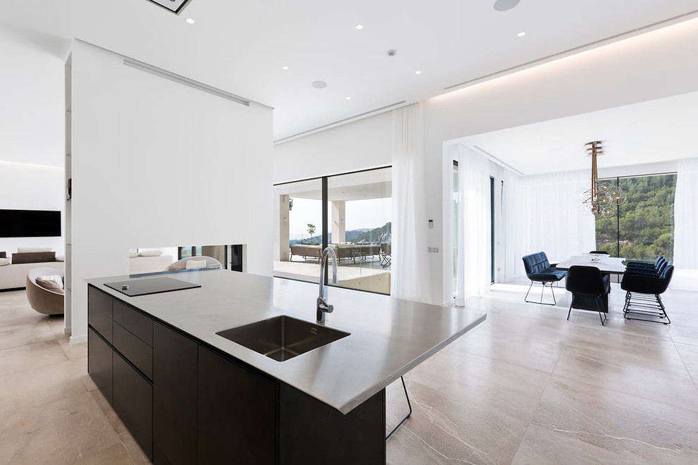 Medium sized contemporary single-wall open plan kitchen in Palma de Mallorca with flat-panel cabinets, black cabinets and an island.