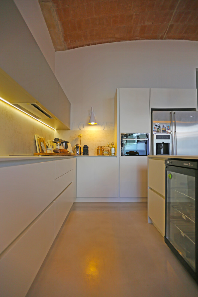 Design ideas for a contemporary kitchen in Barcelona with white cabinets and an island.
