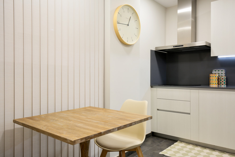 Immagine di una cucina a L nordica chiusa e di medie dimensioni con ante beige, paraspruzzi a effetto metallico, elettrodomestici in acciaio inossidabile, pavimento grigio e top grigio
