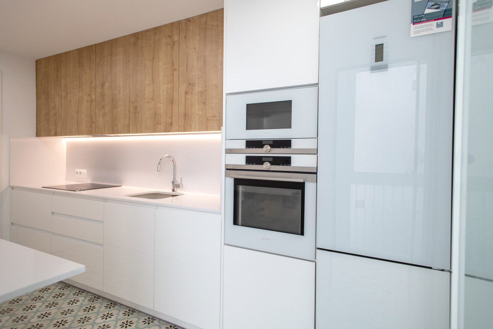 Enclosed kitchen - mid-sized contemporary single-wall ceramic tile and beige floor enclosed kitchen idea in Barcelona with a single-bowl sink, flat-panel cabinets, white cabinets, white backsplash, white appliances, no island and white countertops