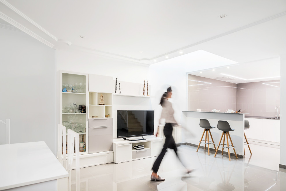 Idéer för att renovera ett mellanstort funkis grå grått kök, med en undermonterad diskho, släta luckor, vita skåp, bänkskiva i kvarts, grått stänkskydd, stänkskydd i porslinskakel, vita vitvaror, klinkergolv i porslin, en halv köksö och grått golv