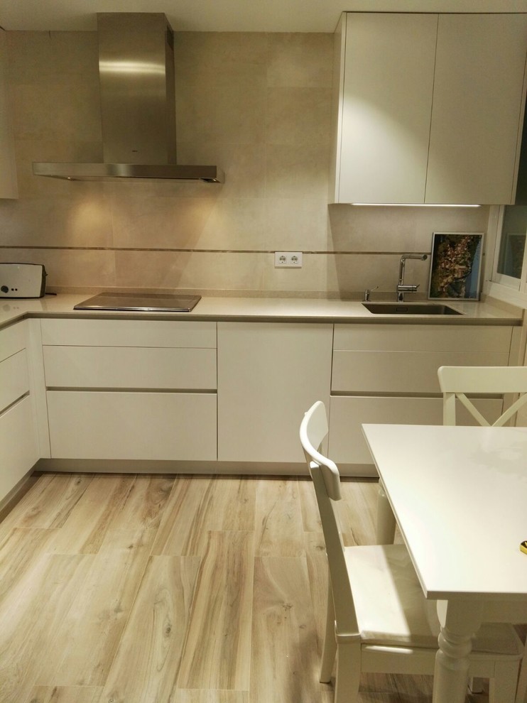 Modern inredning av ett mellanstort kök, med en dubbel diskho, luckor med infälld panel, beige skåp, granitbänkskiva, beige stänkskydd, stänkskydd i sten, rostfria vitvaror och mellanmörkt trägolv