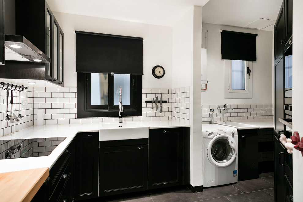 Inspiration for a medium sized traditional l-shaped enclosed kitchen in Barcelona with a built-in sink, flat-panel cabinets, black cabinets, white splashback, metro tiled splashback, white appliances, ceramic flooring and no island.