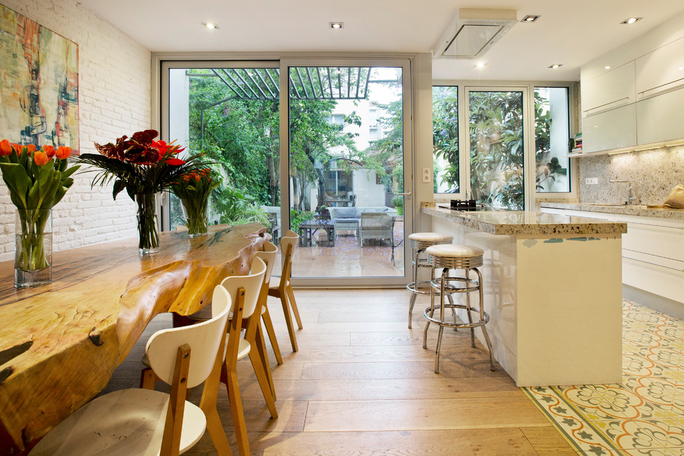 Exempel på ett modernt linjärt kök med öppen planlösning, med släta luckor, vita skåp, rostfria vitvaror och en halv köksö