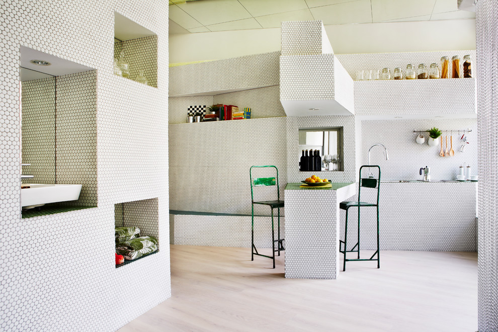 Foto på ett mellanstort funkis l-kök, med öppna hyllor, grå skåp, kaklad bänkskiva, grått stänkskydd, stänkskydd i mosaik, rostfria vitvaror, ljust trägolv och en halv köksö