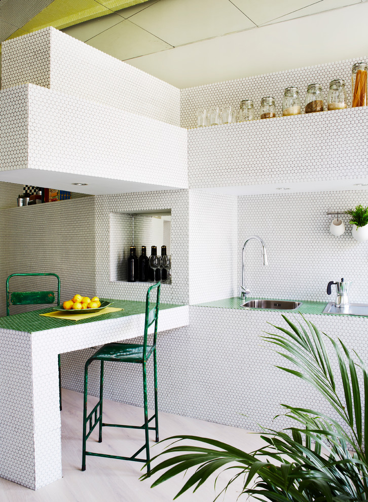 Bild på ett mellanstort funkis l-kök, med öppna hyllor, grå skåp, kaklad bänkskiva, grått stänkskydd, stänkskydd i mosaik, rostfria vitvaror, ljust trägolv och en halv köksö
