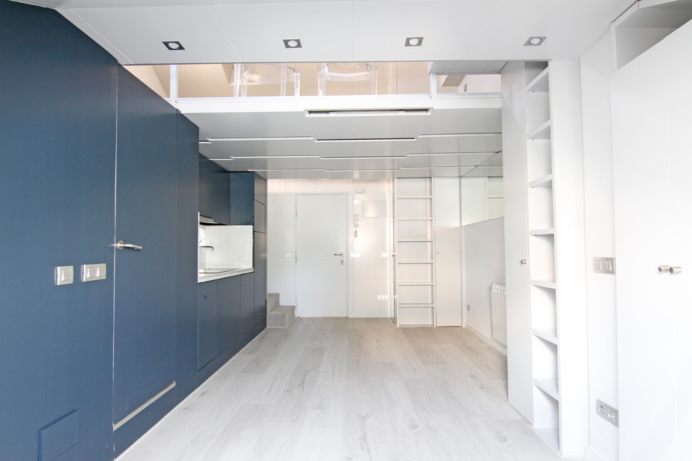 Modern inredning av ett litet vit linjärt vitt kök med öppen planlösning, med en undermonterad diskho, luckor med infälld panel, skåp i mörkt trä, marmorbänkskiva, vitt stänkskydd, stänkskydd i marmor, integrerade vitvaror, laminatgolv och vitt golv