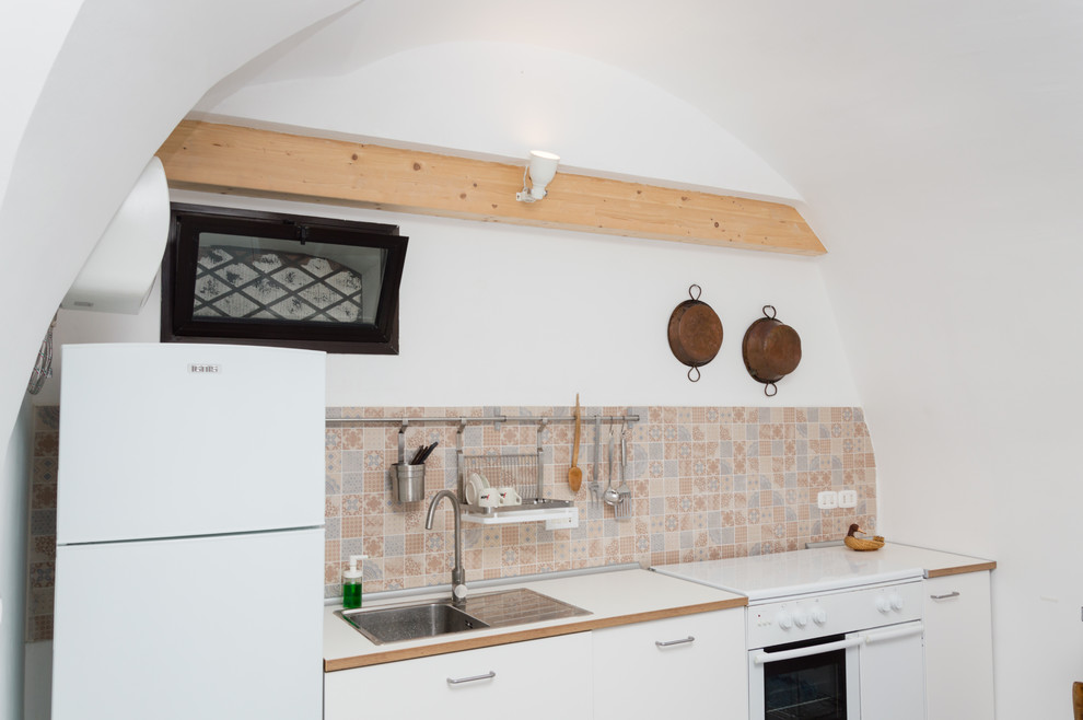 他の地域にある低価格の小さな地中海スタイルのおしゃれなI型キッチン (シングルシンク、マルチカラーのキッチンパネル) の写真