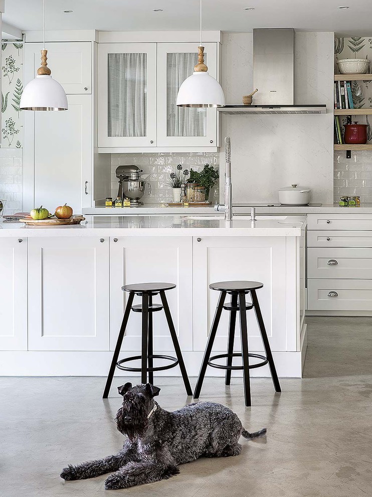Inspiration for a mid-sized shabby-chic style u-shaped concrete floor and gray floor open concept kitchen remodel in Madrid with an undermount sink, shaker cabinets, white cabinets, quartz countertops, white backsplash, subway tile backsplash, white appliances, a peninsula and white countertops