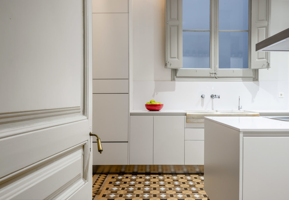 Cette photo montre une cuisine tendance de taille moyenne avec des portes de placard blanches, une crédence blanche, îlot et un plan de travail blanc.