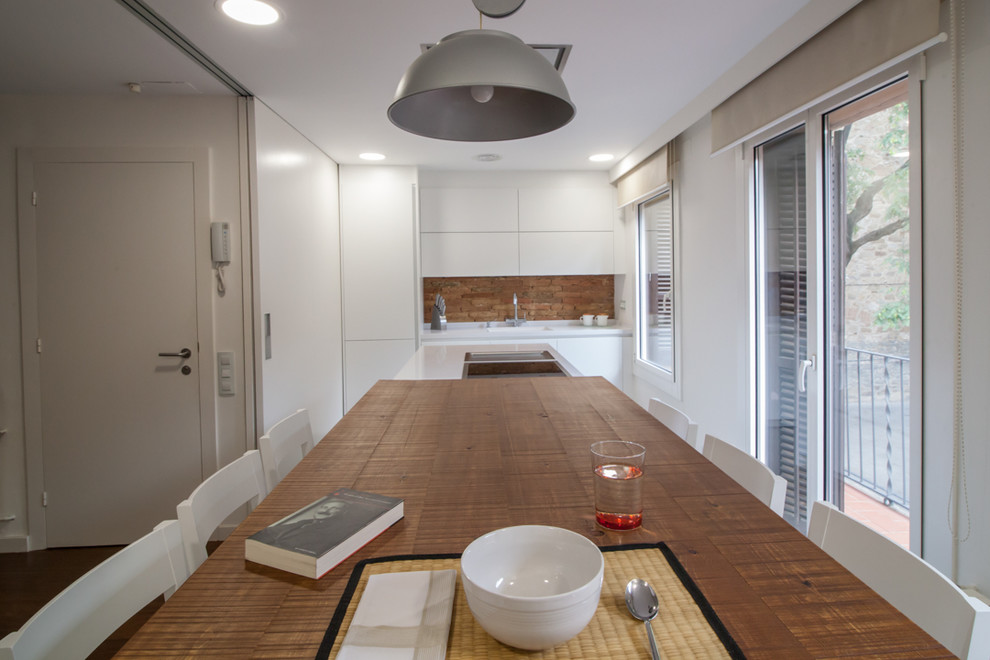 Modelo de cocina comedor lineal contemporánea de tamaño medio con armarios con paneles lisos, puertas de armario blancas, electrodomésticos con paneles y una isla