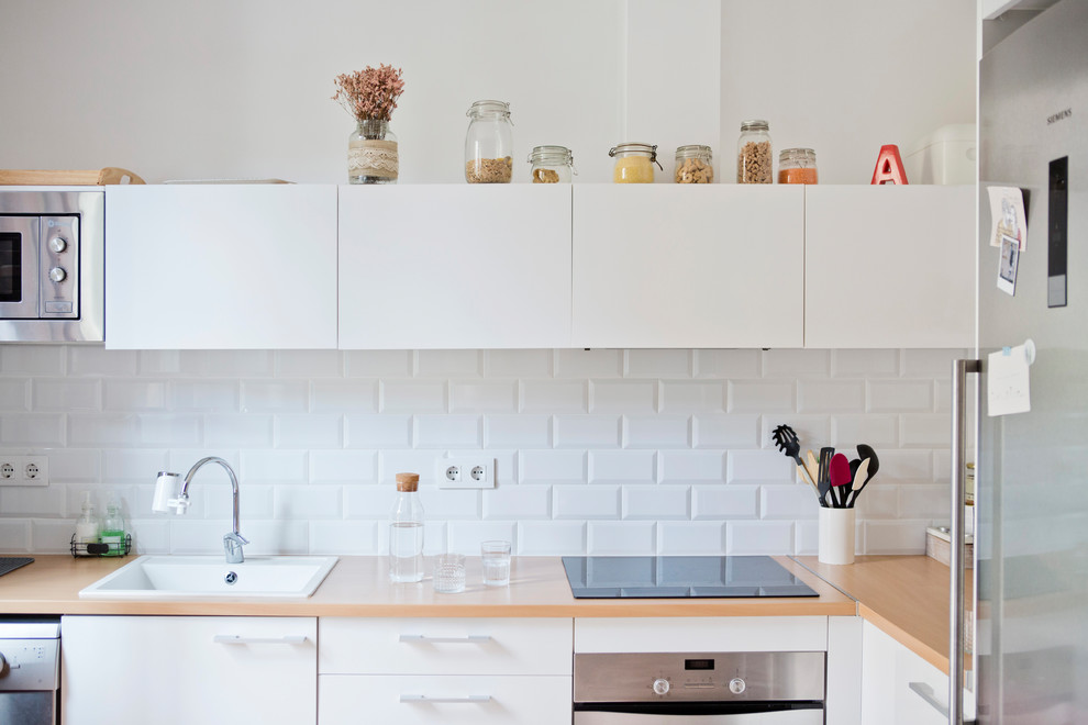 На фото: кухня в скандинавском стиле с белым фартуком и фартуком из плитки кабанчик с
