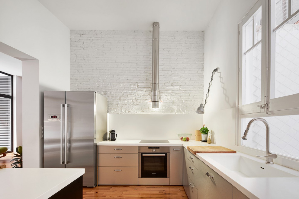 Inspiration for a contemporary l-shaped medium tone wood floor and brown floor kitchen remodel in Barcelona with an integrated sink, flat-panel cabinets, gray cabinets, an island and white countertops
