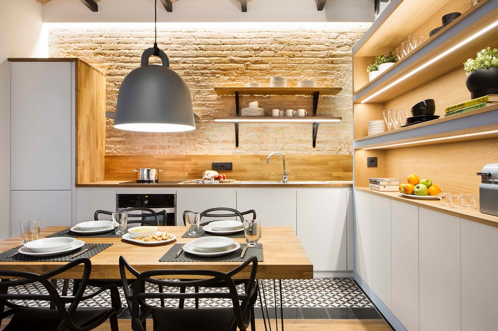 Inspiration for a mid-sized coastal l-shaped eat-in kitchen remodel in Barcelona with flat-panel cabinets, white cabinets, wood countertops, brown backsplash, wood backsplash, paneled appliances and no island