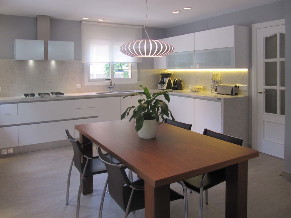 Inspiration for a medium sized classic grey and white l-shaped kitchen/diner in Other with a double-bowl sink, flat-panel cabinets, white cabinets, stainless steel appliances, no island, granite worktops, grey splashback, granite splashback, cement flooring, grey floors and grey worktops.