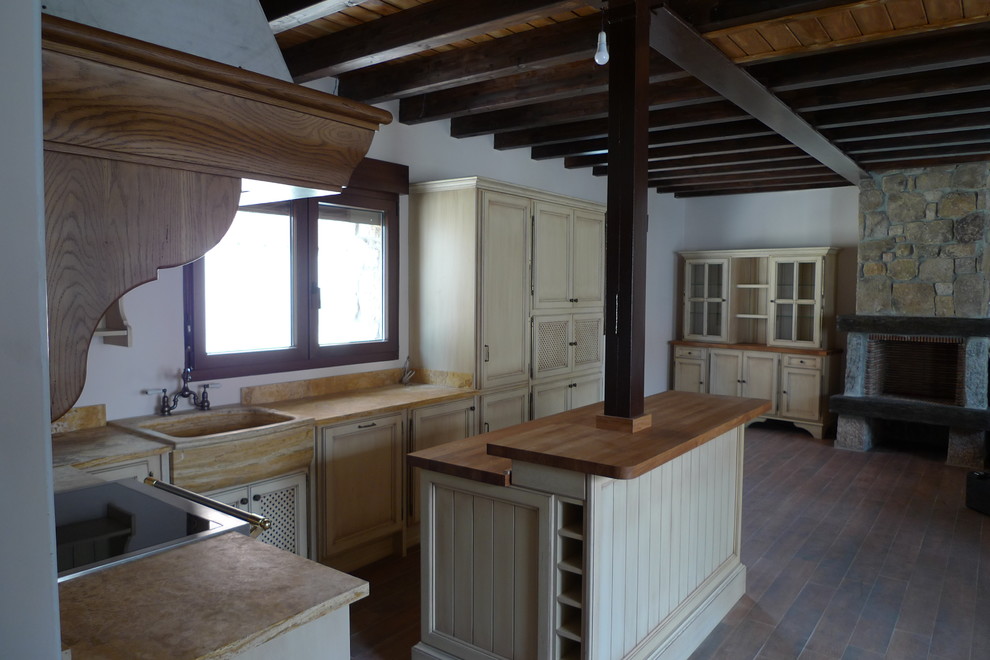 Immagine di una cucina rustica di medie dimensioni con lavello da incasso, ante a filo, ante in legno chiaro, elettrodomestici da incasso, pavimento con piastrelle in ceramica e pavimento marrone
