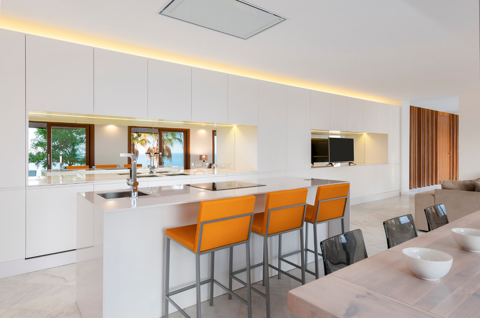 Imagen de cocina contemporánea grande abierta con armarios con paneles lisos, puertas de armario blancas, electrodomésticos con paneles y una isla