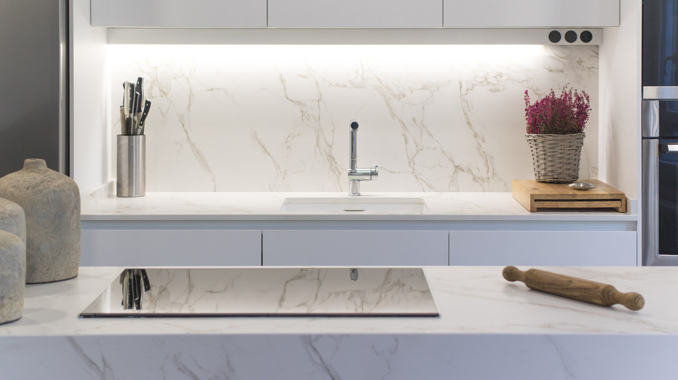 Immagine di una cucina minimal con ante lisce, ante bianche, top in marmo, paraspruzzi bianco e paraspruzzi in marmo