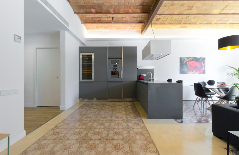 Cette image montre une cuisine ouverte linéaire design de taille moyenne avec un placard à porte plane, des portes de placard grises et une péninsule.