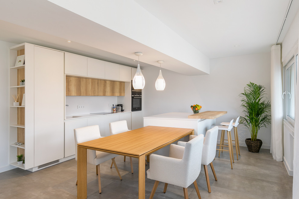 Medium sized modern single-wall open plan kitchen in Madrid with white cabinets, white splashback, black appliances, ceramic flooring, multiple islands, grey floors and white worktops.