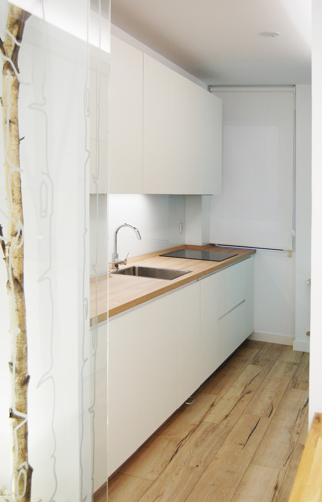 Источник вдохновения для домашнего уюта: маленькая отдельная, прямая кухня в скандинавском стиле с одинарной мойкой, плоскими фасадами, белыми фасадами, белым фартуком и светлым паркетным полом без острова для на участке и в саду