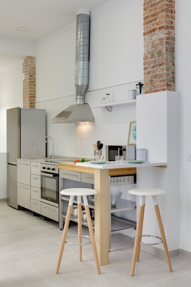 Einzeilige Moderne Küche mit flächenbündigen Schrankfronten, grauen Schränken, Küchengeräten aus Edelstahl, grauem Boden und grauer Arbeitsplatte in Alicante-Costa Blanca