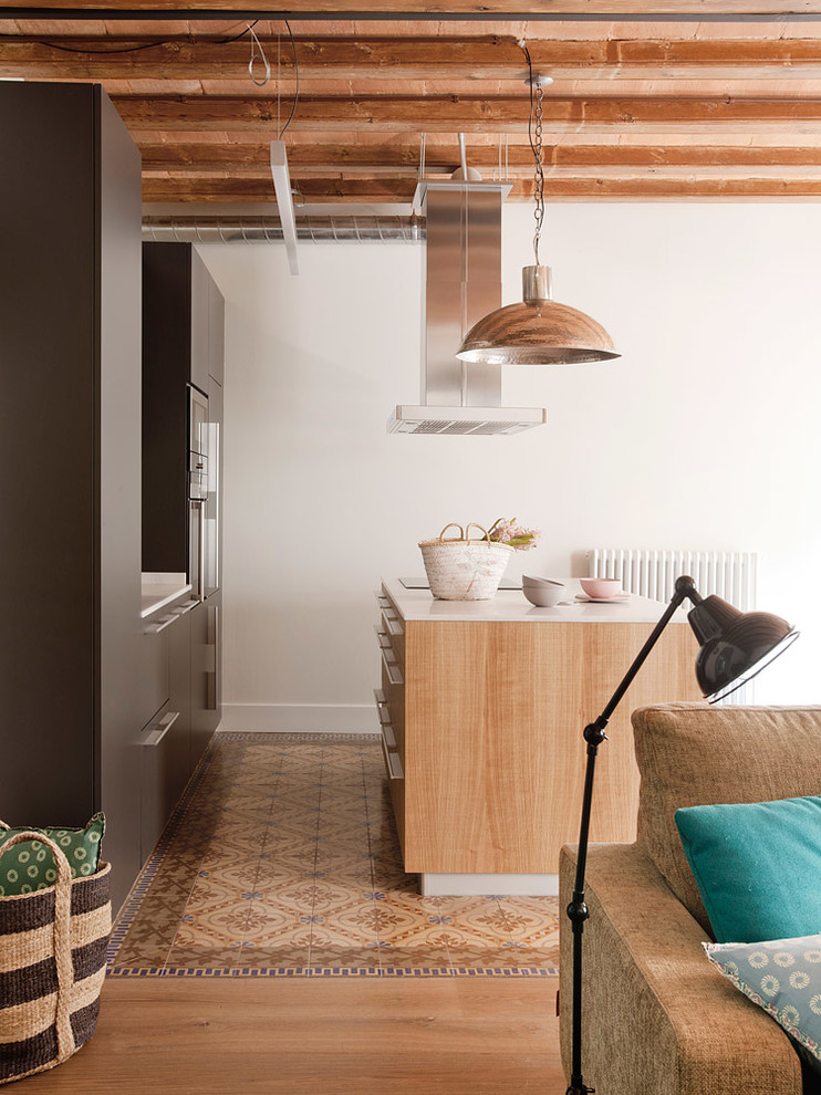 This is an example of a medium sized scandinavian single-wall open plan kitchen in Barcelona with flat-panel cabinets, ceramic flooring and an island.