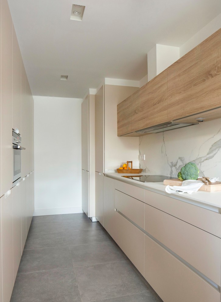 Idées déco pour une cuisine parallèle romantique de taille moyenne avec un placard à porte plane, des portes de placard beiges, une crédence blanche, une crédence en marbre et un sol gris.