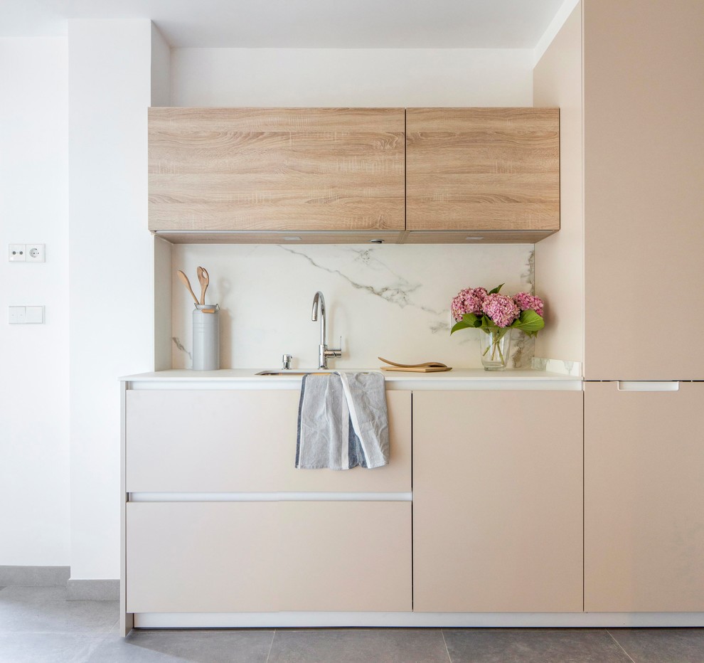 Ispirazione per una piccola cucina lineare minimal con ante lisce, ante beige, paraspruzzi bianco, paraspruzzi in marmo, pavimento grigio e lavello sottopiano